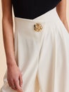 Pantalon élégant pour femme en beige clair, coupe fluide et détail chic à la taille