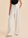 Vue de face du pantalon femme taille haute beige avec jambe large et bouton doré décoratif